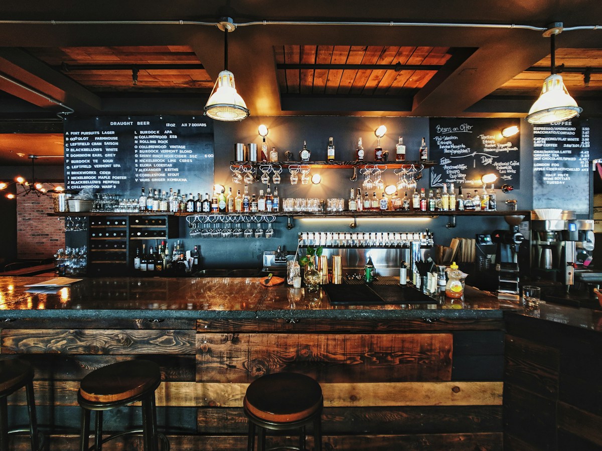 The Sitting Bar speakeasy counter with backlit spirits library and crystal mixology glasses